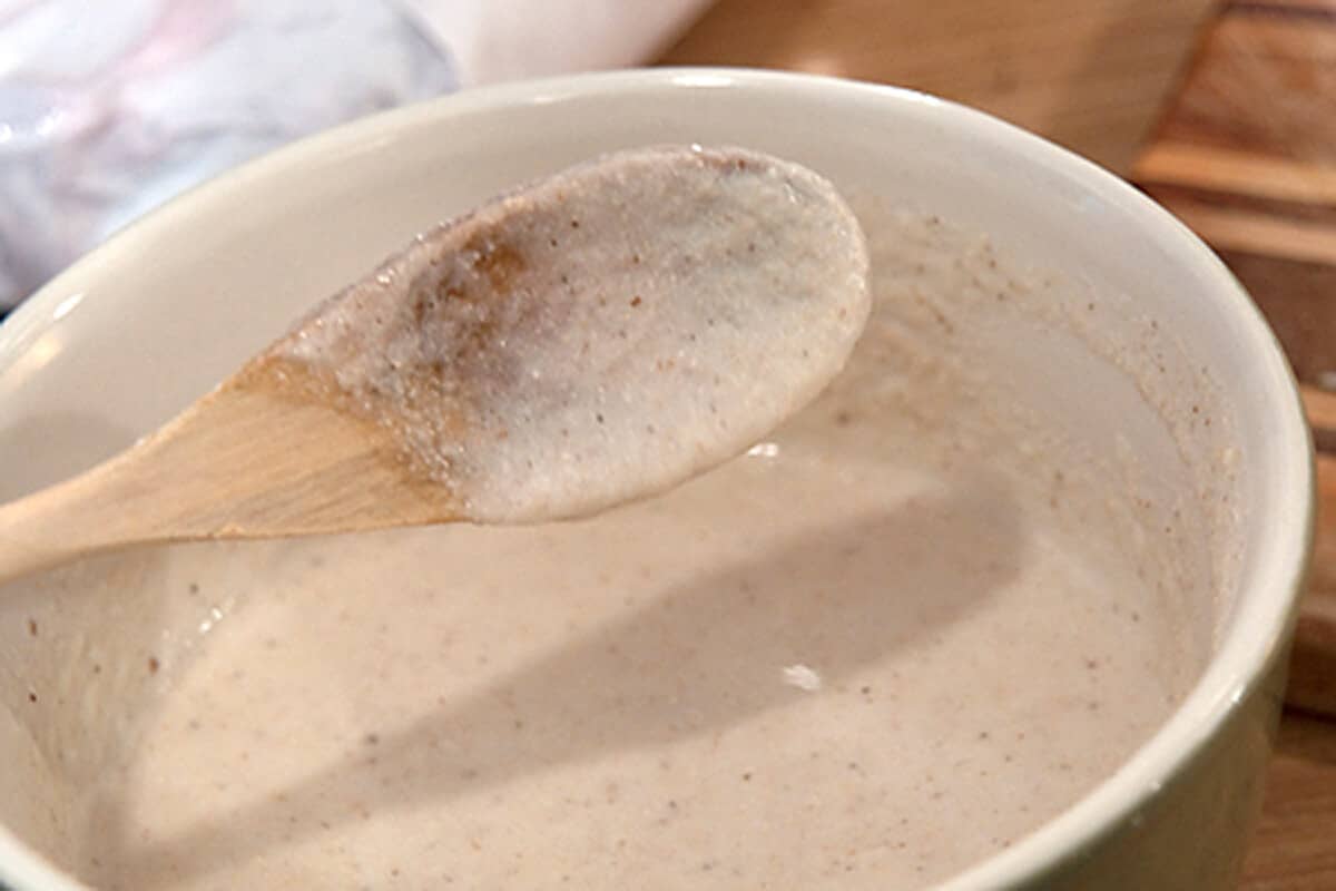 Lacy Cornbread batter Mixed batter coating a wooden spoon.