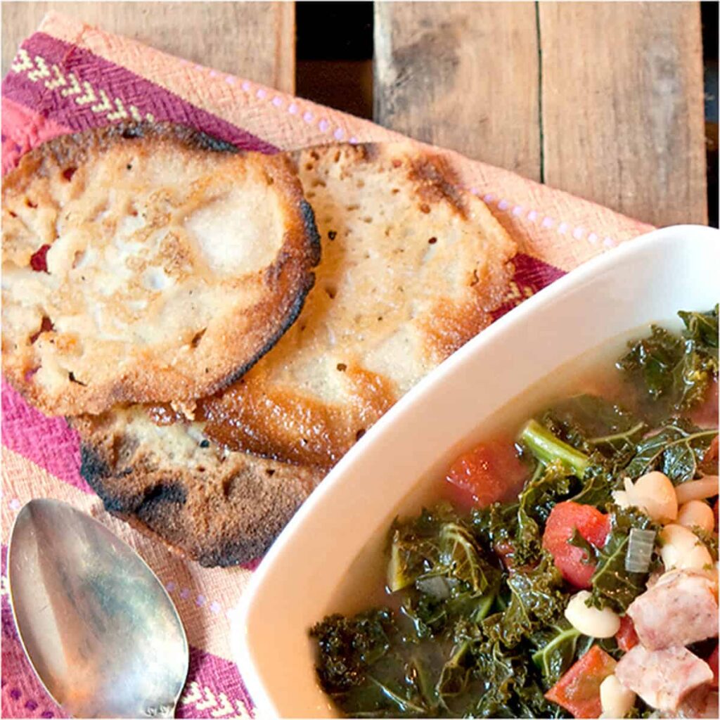 Lacy cornbread alongside a bowl of soup.