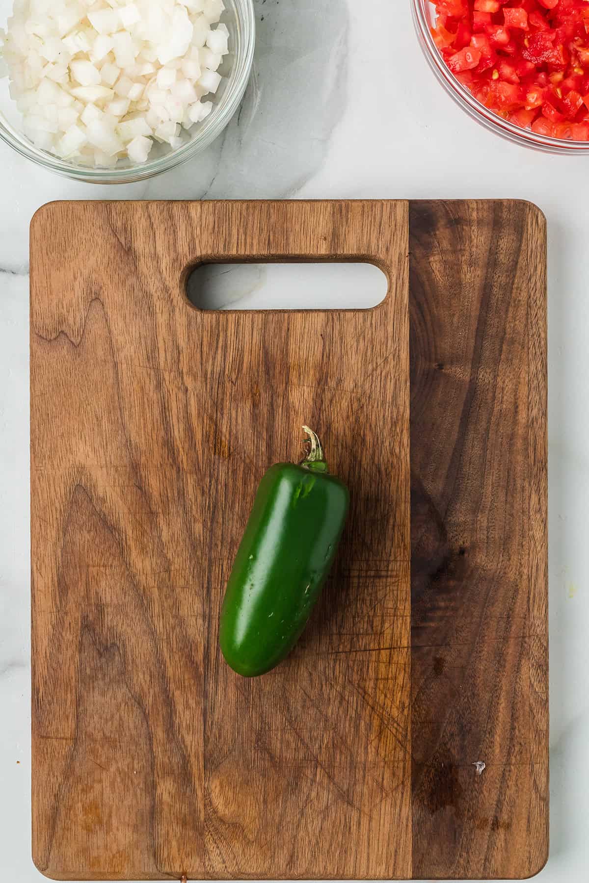 Jalapeno on a wooden cutting board.