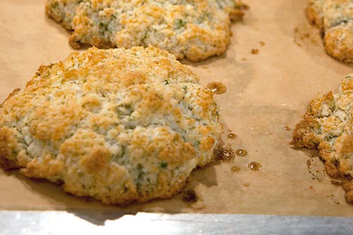 Golden brown, freshly baked biscuits on parchment paper.