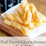 Puff Pastry Cheese Straws mounded on a serving board. Text overlay for pinning.