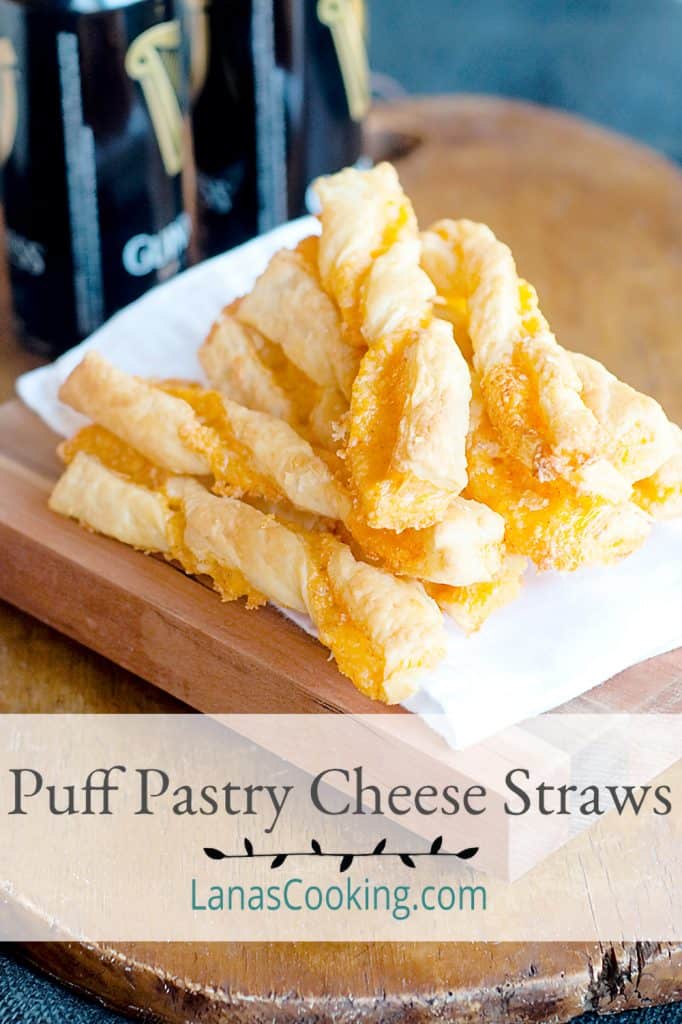 Puff Pastry Cheese Straws mounded on a serving board. Text overlay for pinning.