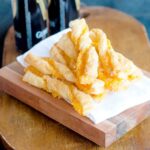 Puff Pastry Cheese Straws mounded on a serving board.