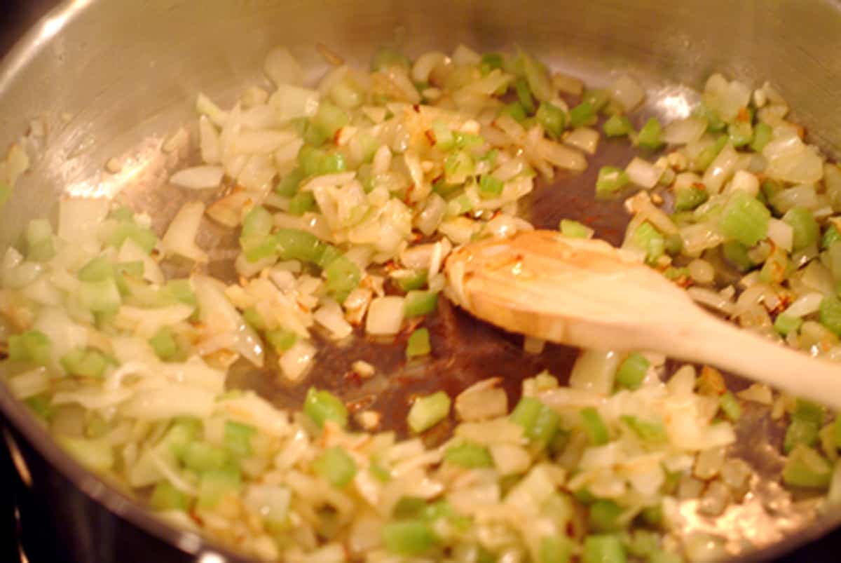 Sauteeing onions, celery and garlic in a skillet.