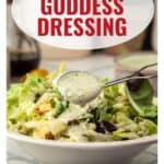 A spoon drizzles green goddess dressing over a fresh salad, with text: Green Goddess Dressing.