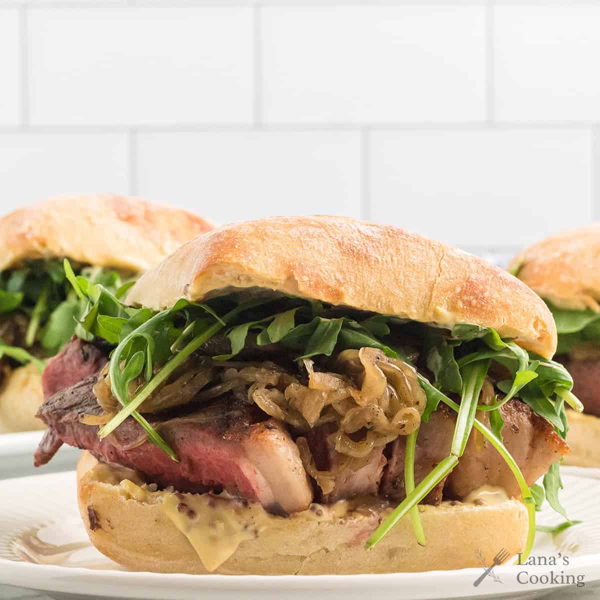 Finished steak sandwich on a serving plate.
