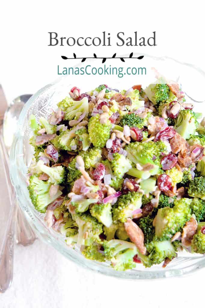 Broccoli Salad in a glass serving bowl with vintage serving utensils. Text overlay for pinning.