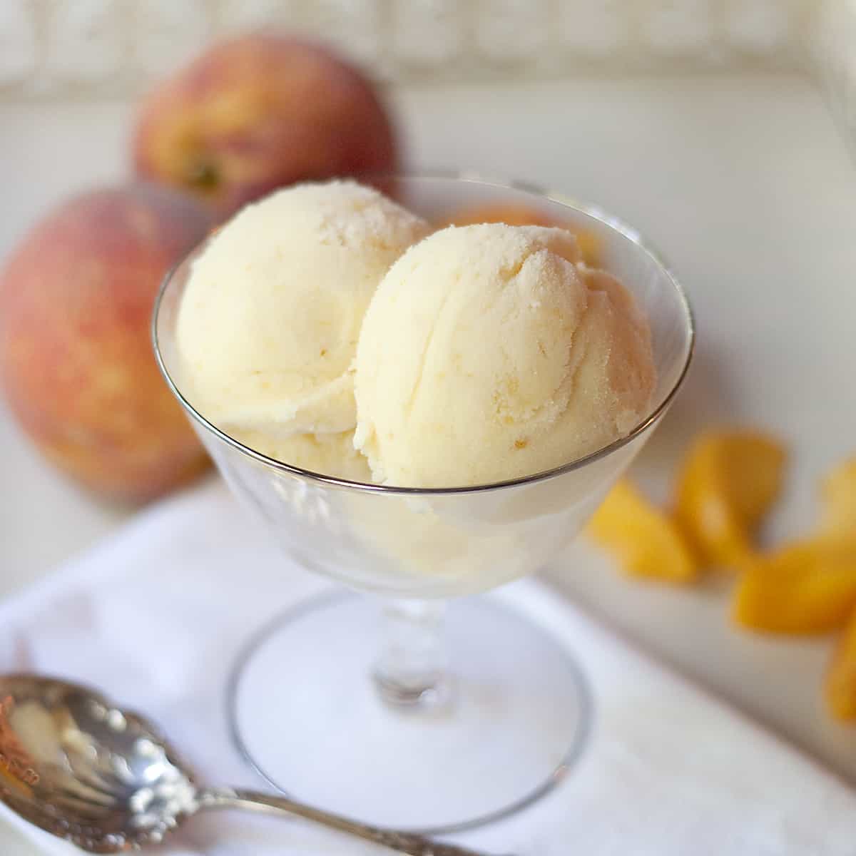 Creamy, cold and delicious homemade peach ice cream with sweet, fresh Georgia grown peaches and rich with eggs, heavy cream, and whole milk. https://www.lanascooking.com/homemade-peach-ice-cream/