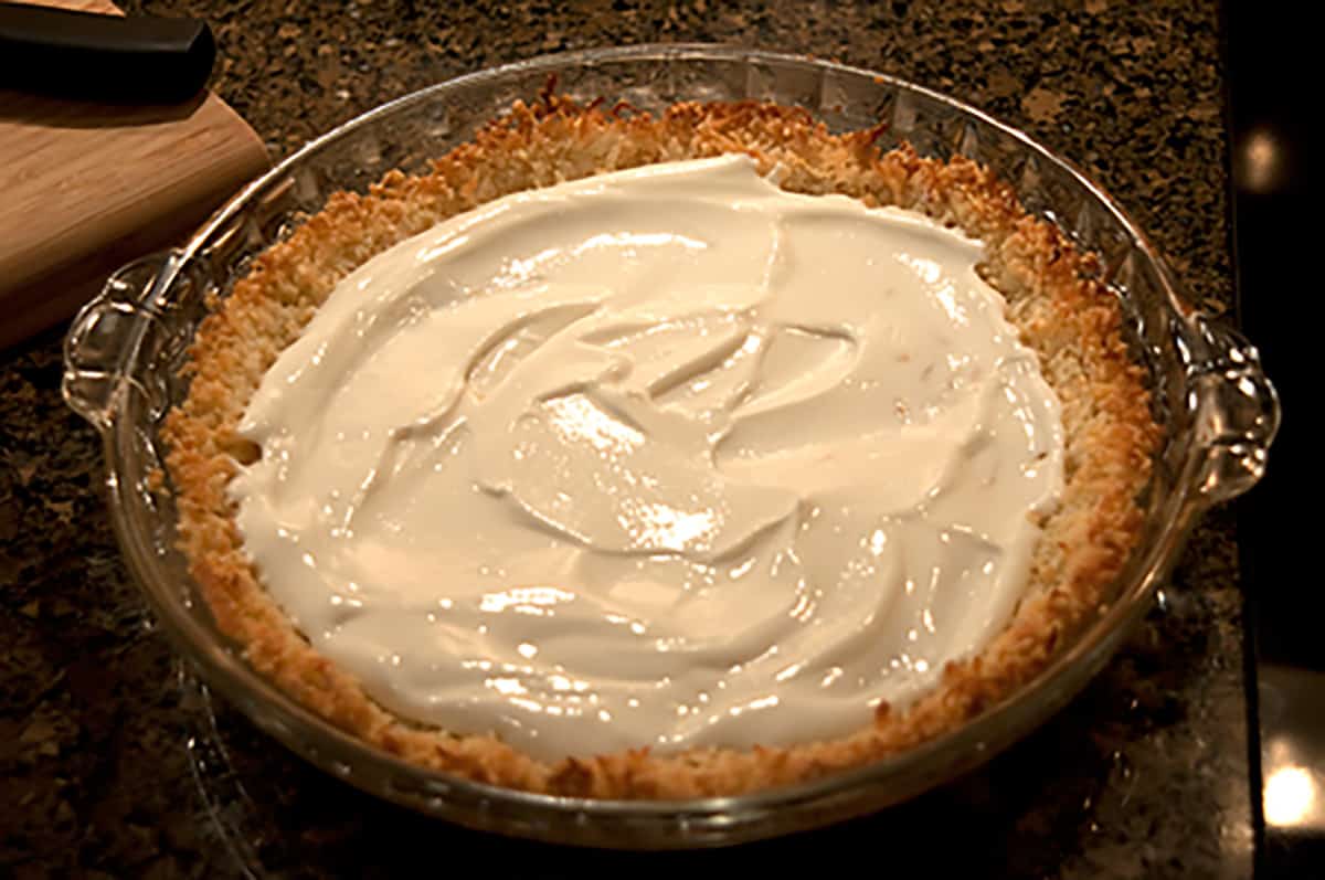 Filling added to pie crust in a glass plate.