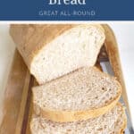 Loaf of homemade bread with slices on a wooden cutting board.