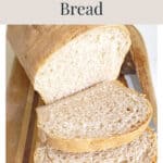 A loaf of homemade bread sliced on a wooden cutting board.