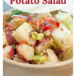 Bowl of lemon dill potato salad with red potatoes, dill, and chopped vegetables; recipe title above.