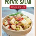 Bowl of lemon dill potato salad with herbs and veggies, displayed beneath a recipe title and website link.
