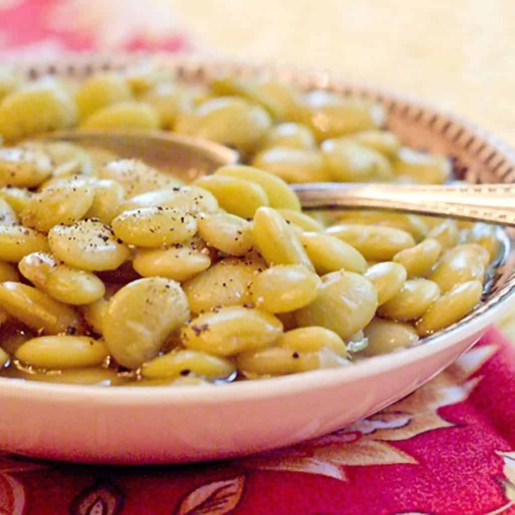 Butter beans in a serving bowl with a spoon.