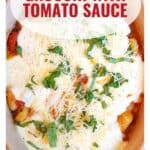 Baked gnocchi with tomato sauce, melted cheese, basil, and grated parmesan in a dish.