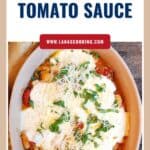 Baked gnocchi in tomato sauce topped with melted cheese, fresh basil, and grated parmesan in a casserole dish.