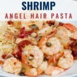 A plate of Mediterranean shrimp with angel hair pasta, garnished with capers and diced vegetables, served on a white dish.