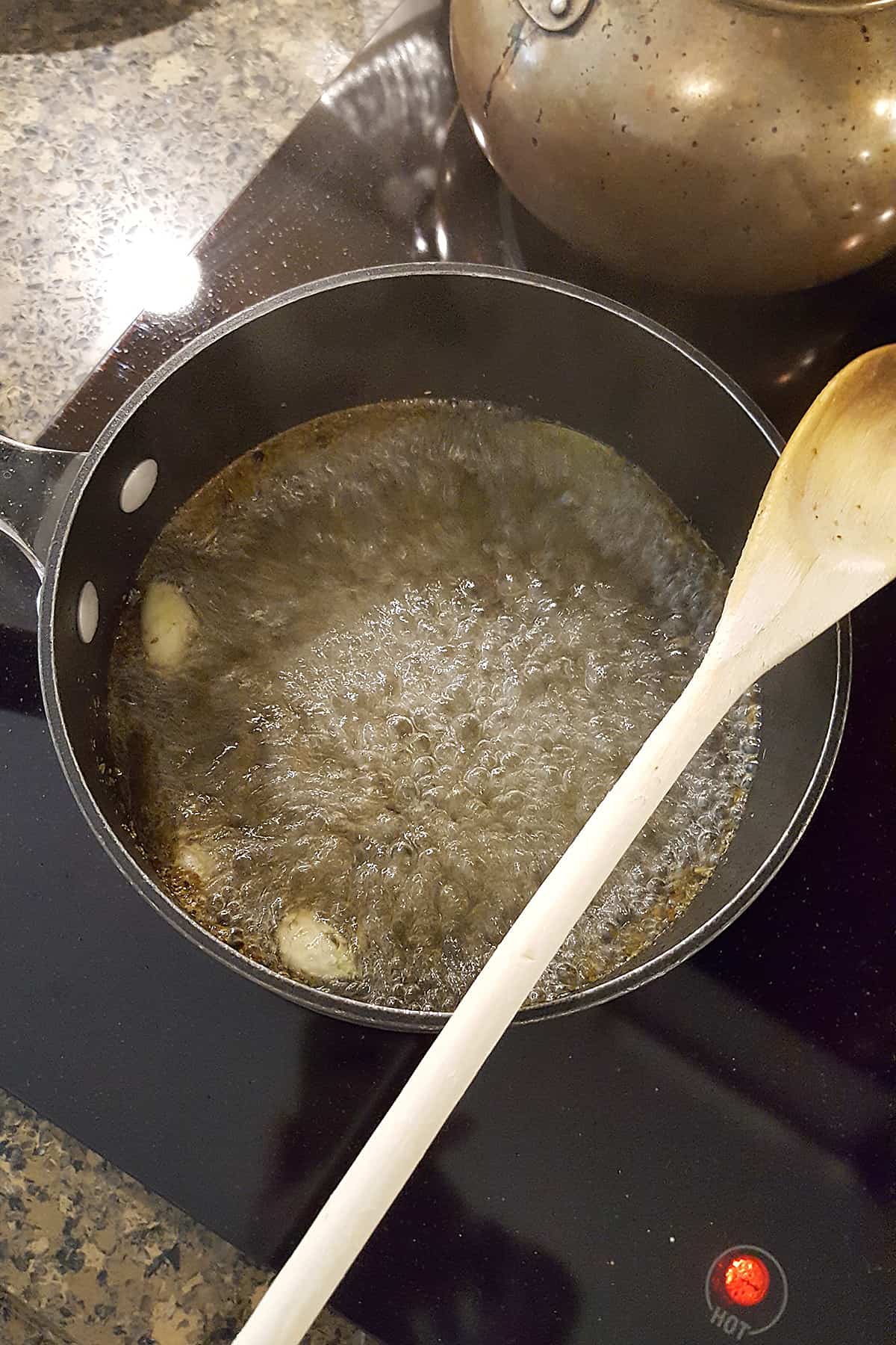 Brine mixture boiling in saucepan on stovetop.
