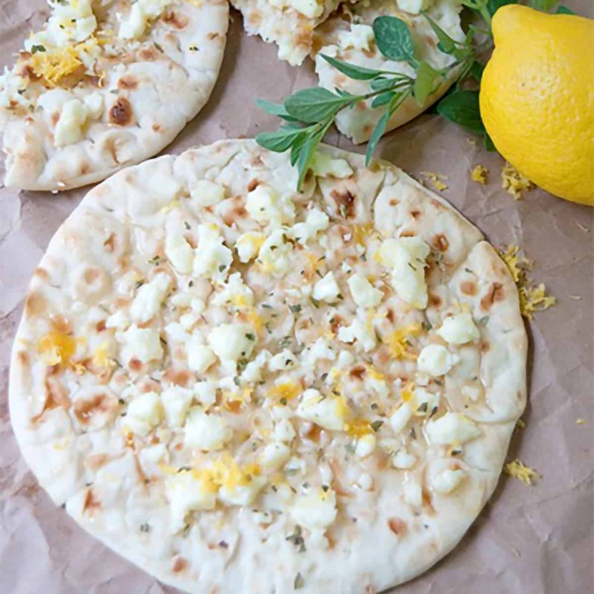 Flatbread topped with cheese, lemon zest, and oregano.