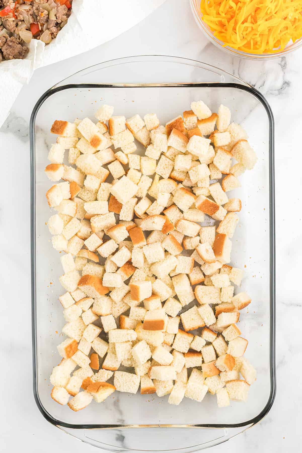 Bread cubes layered in a baking dish.