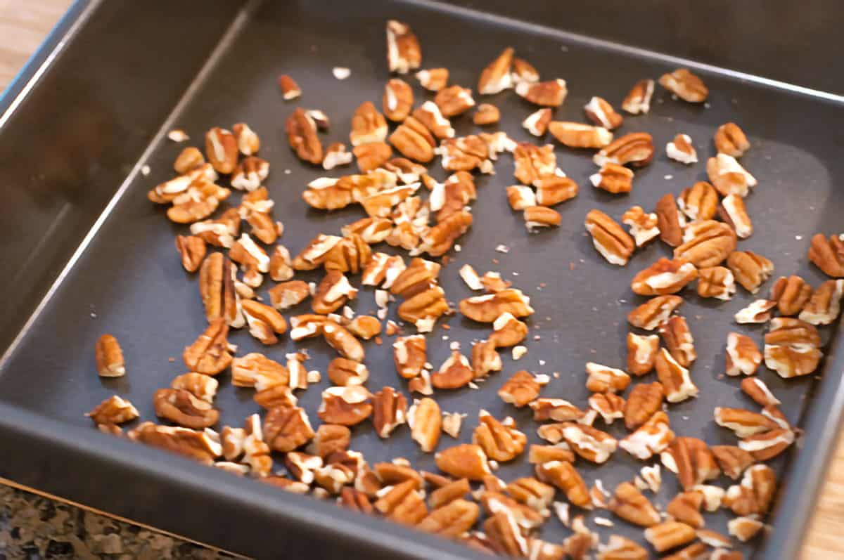 Chopped pecans in a baking pan.