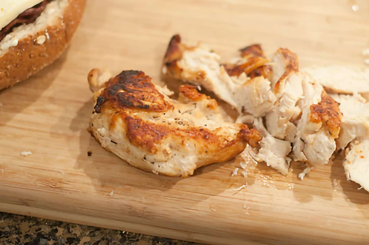 Cooked, sliced chicken breasts on a cutting board