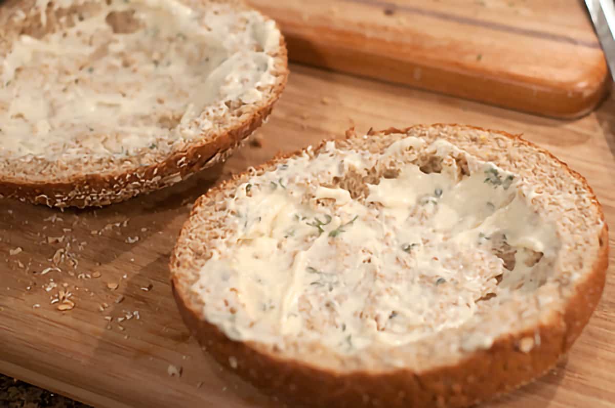 Whole wheat bread boule sliced open and spread with mayonnaise mixture
