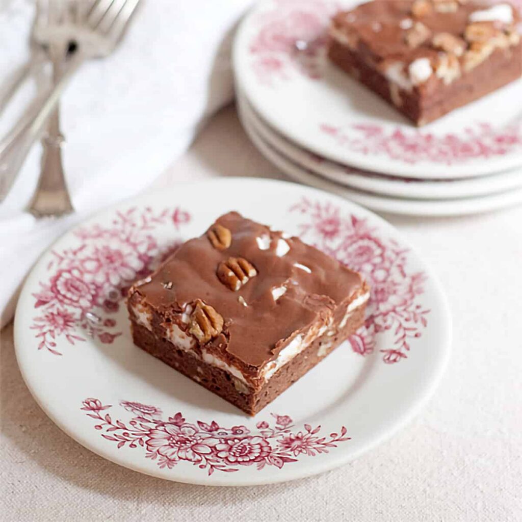 A vintage recipe for Mississippi Mud Cake - a brownie cake base topped with melted marshmallows and drizzled with chocolate frosting. https://www.lanascooking.com/mississippi-mud-cake/