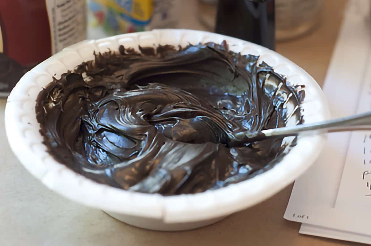 Bowl containing black frosting mixture.