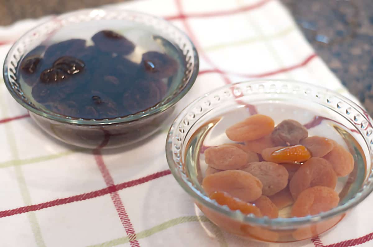 Soaking dried apricots and prunes Prunes and apricots soaking in water in two small bowls