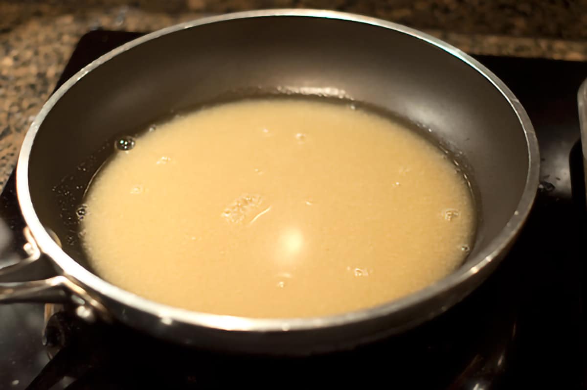 Pan juices from cooking in a skillet on the stovetop