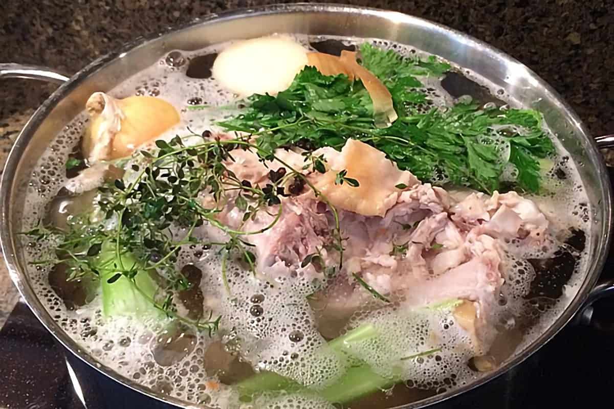 Ingredients for turkey broth simmering in a large stock pot.