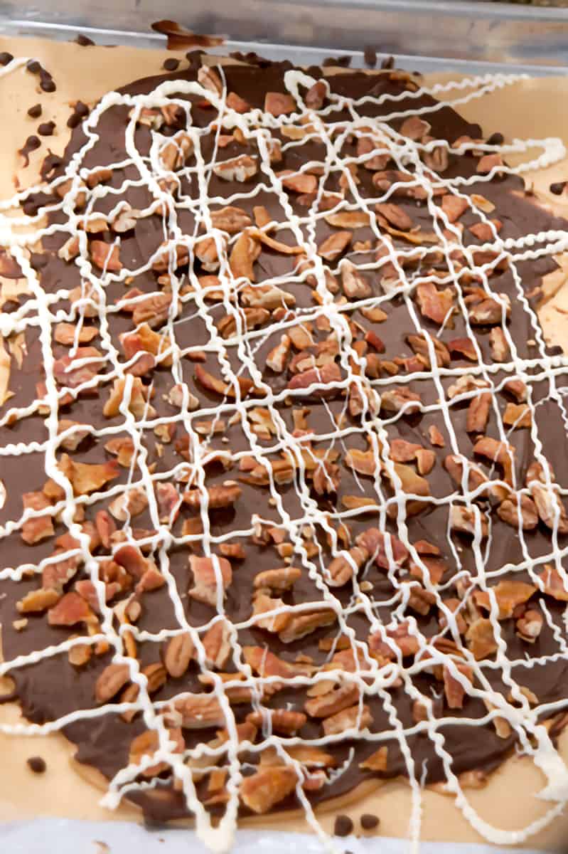Finished Pecan and Bacon Topped Toffee with white chocolate drizzled over.