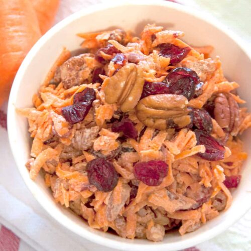 Carrot Cranberry Salad in a serving bowl on a kitchen towel.