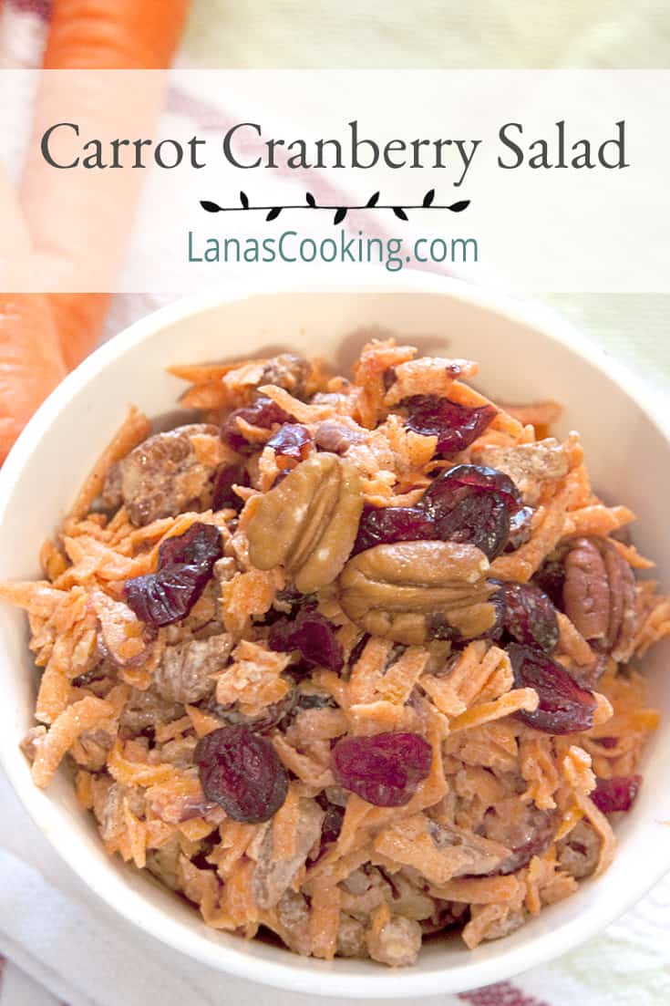 Carrot Cranberry Salad in a serving bowl on a kitchen towel. Text overlay for pinning.