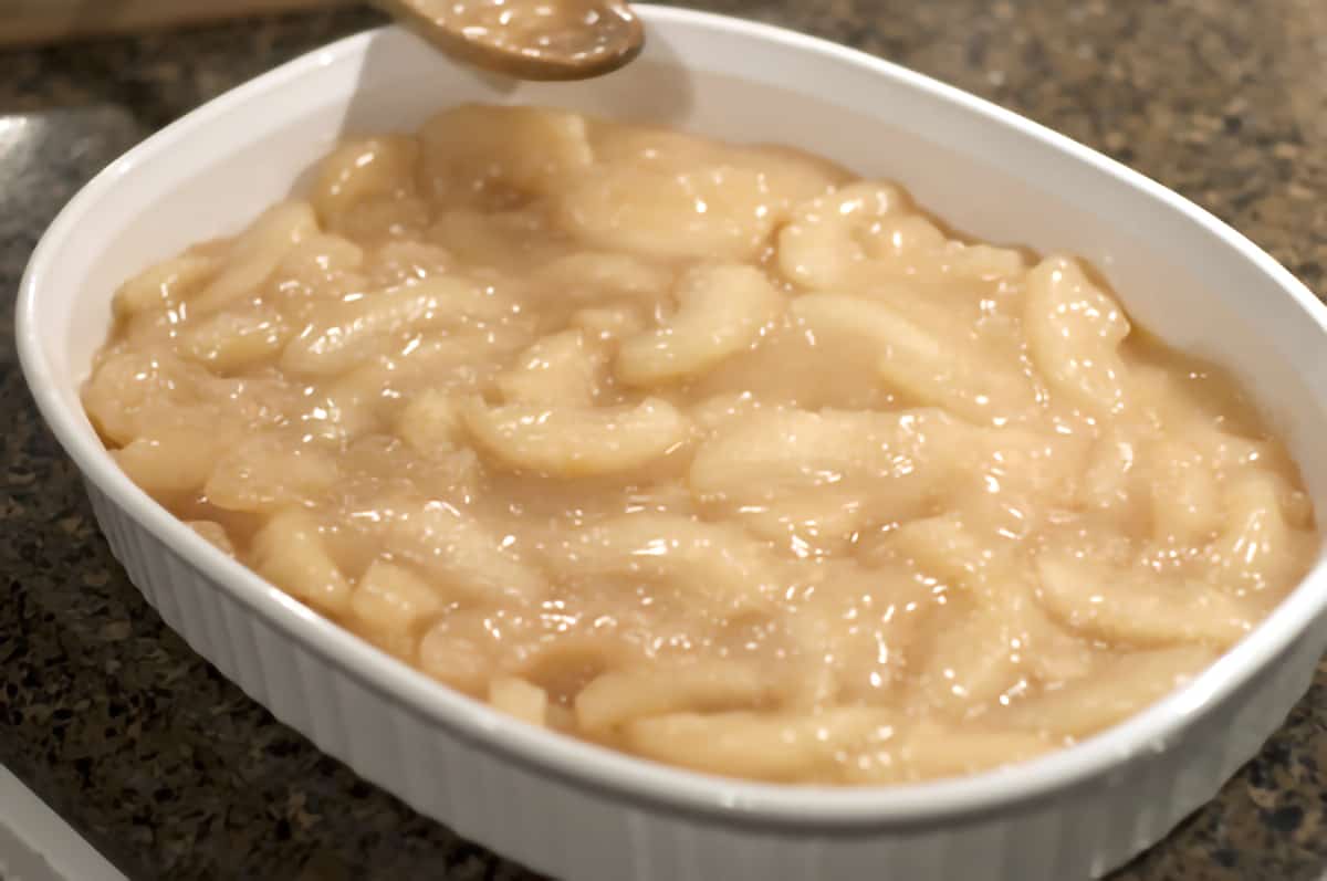 Baking dish with a layer of apple pie filling.