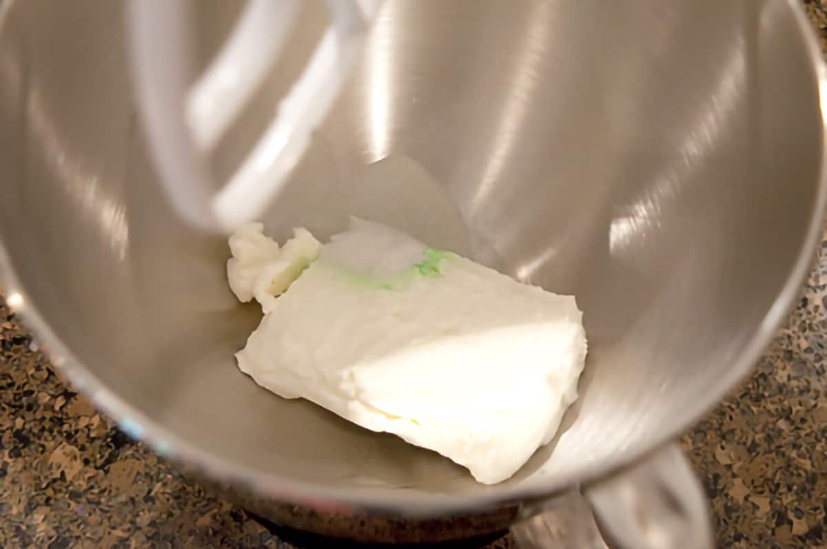 Softened cream cheese and jello in the bowl of a stand mixer.