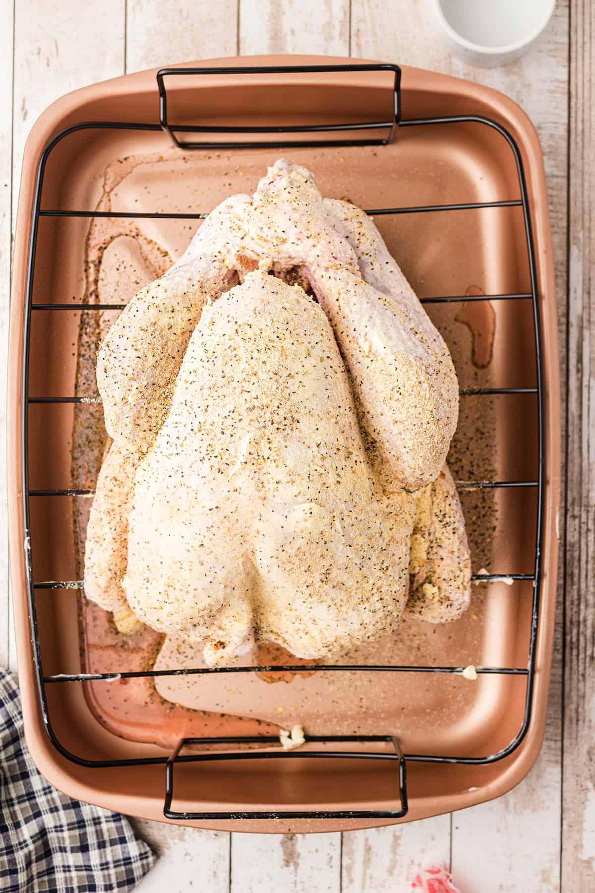 Turkey in roasting pan coated with butter and seasoned salt.