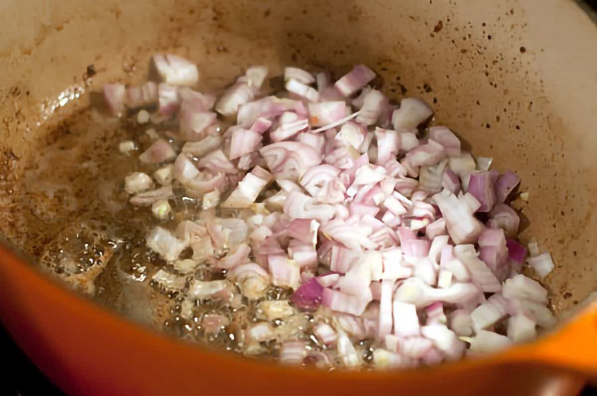 Shallots cooking in pan where pork loin was browned.