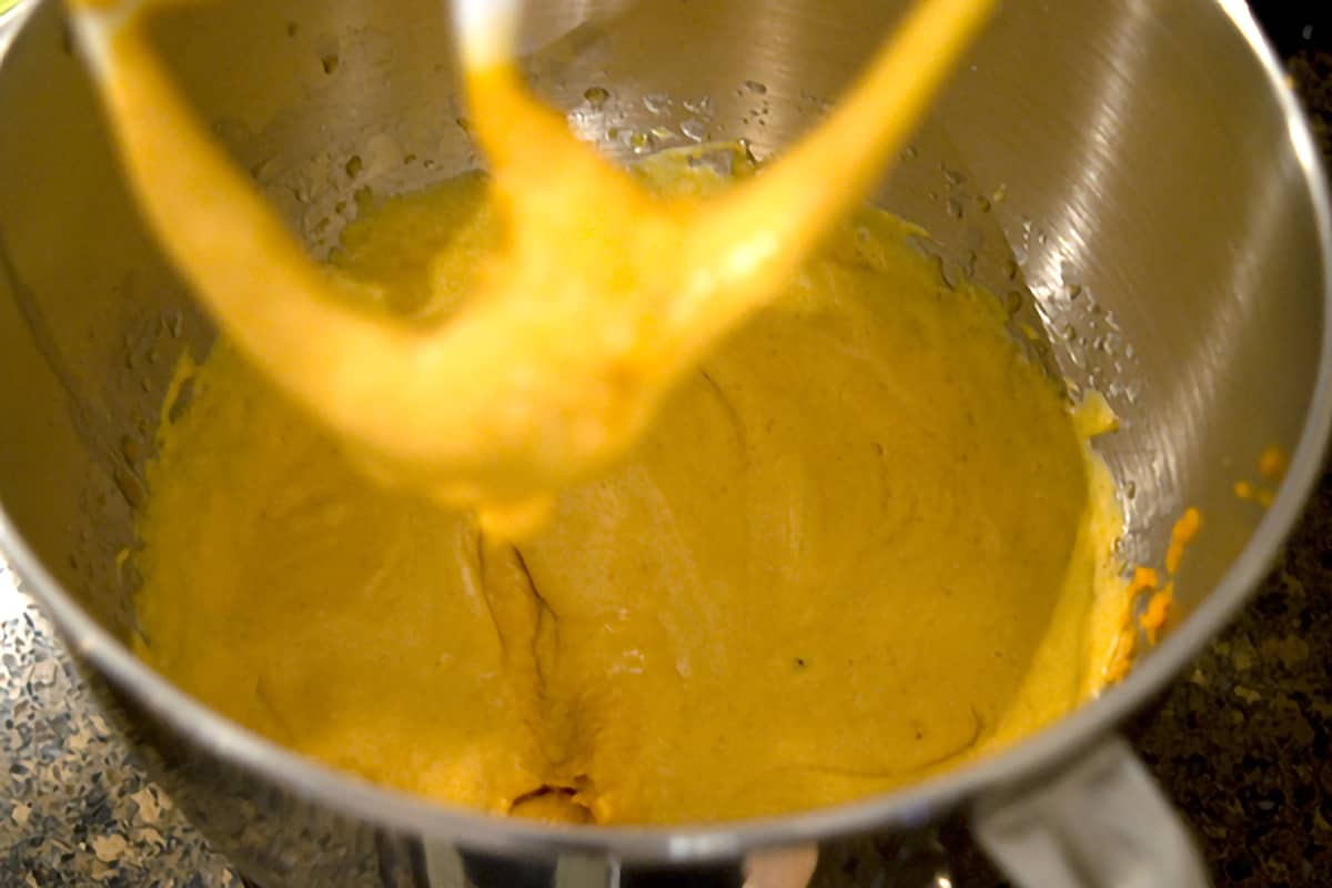 Mixing bowl with butter, sugar, egg, and pumpkin mixture.