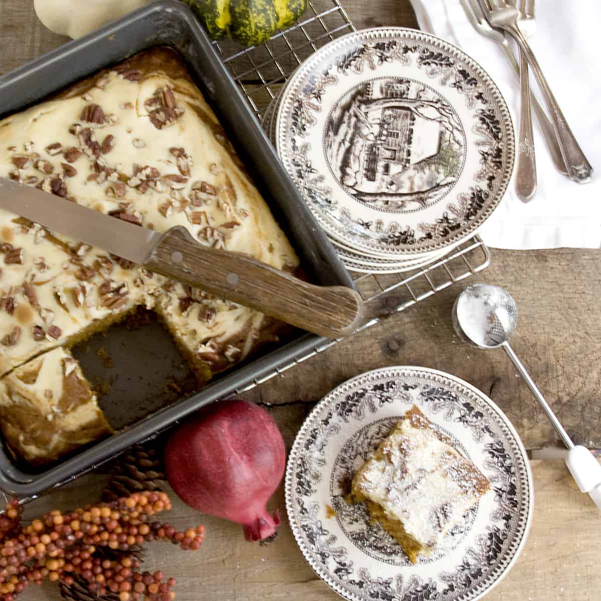 A serving of Pumpkin Cream Cheese Brownies on a plate dusted with powdered sugar.