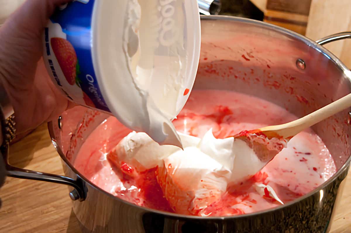 Add Cool Whip to Polly's Pink Stuff Folding cool whip into the jello mixture.