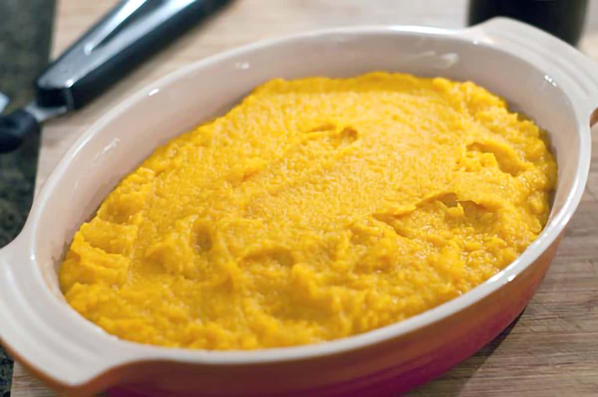 An oval baking dish containing the mashed sweet potato mixture.
