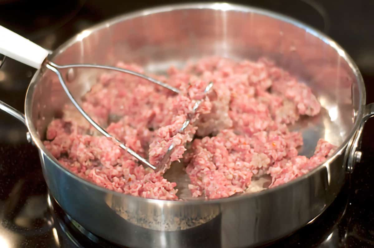Country sausage cooking in a large skillet.