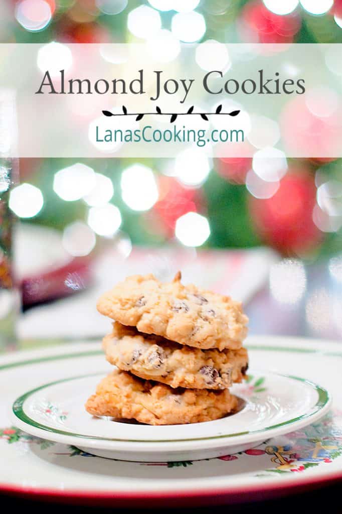 Almond Joy Cookies on a Christmas plate with twinkling lights in the background. Text overlay for pinning.