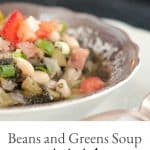 A bowl of Beans and Greens Soup with a spoon in the foreground. Text overlay for pinning.