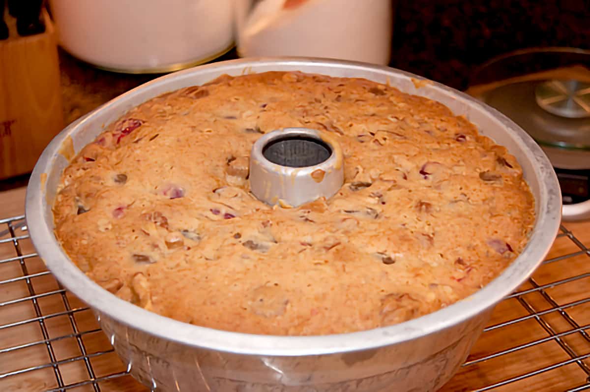 Cooked fruitcake in the baking pan sitting on a cooling rack.