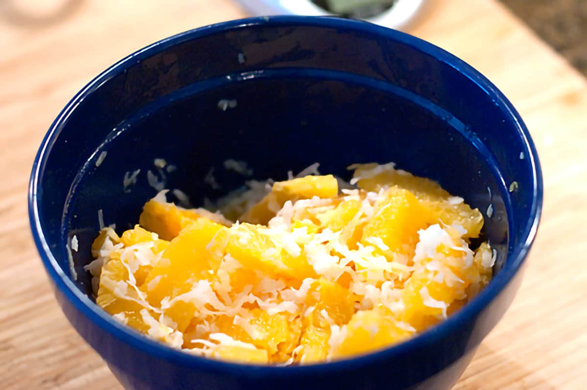 Mixing bowl containing oranges and coconut.