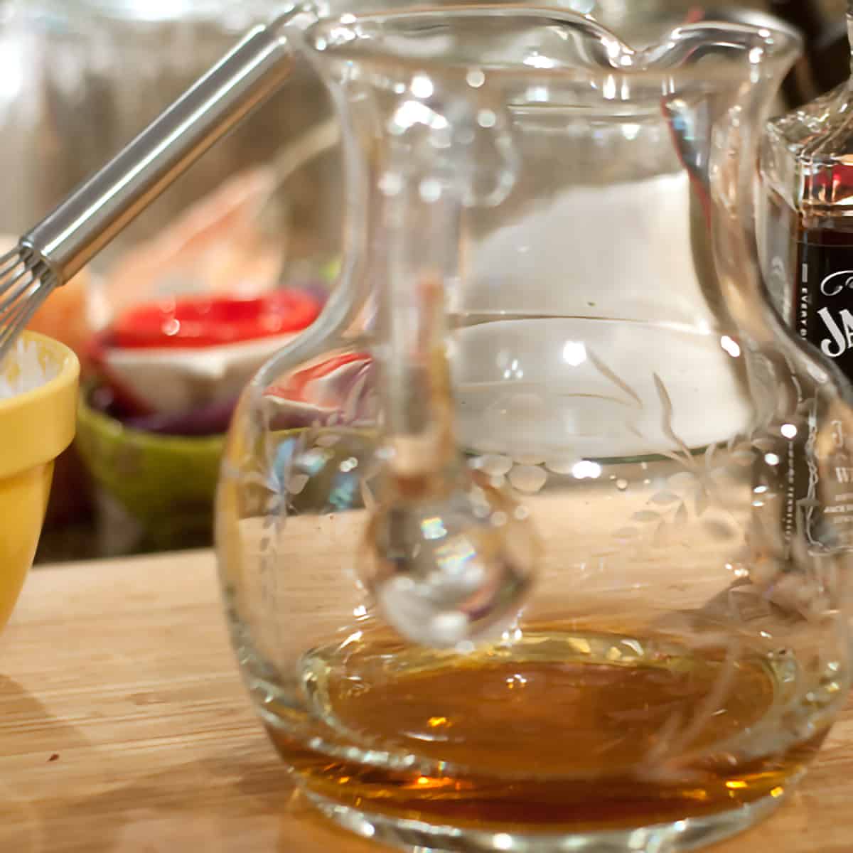 Glass pitcher containing bourbon.