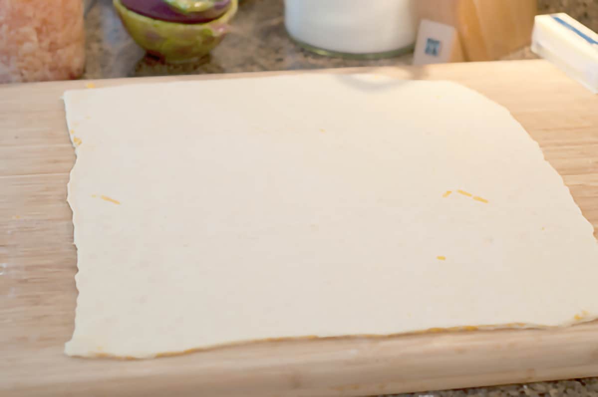 Layered puff pastry rolled out on a cutting board.